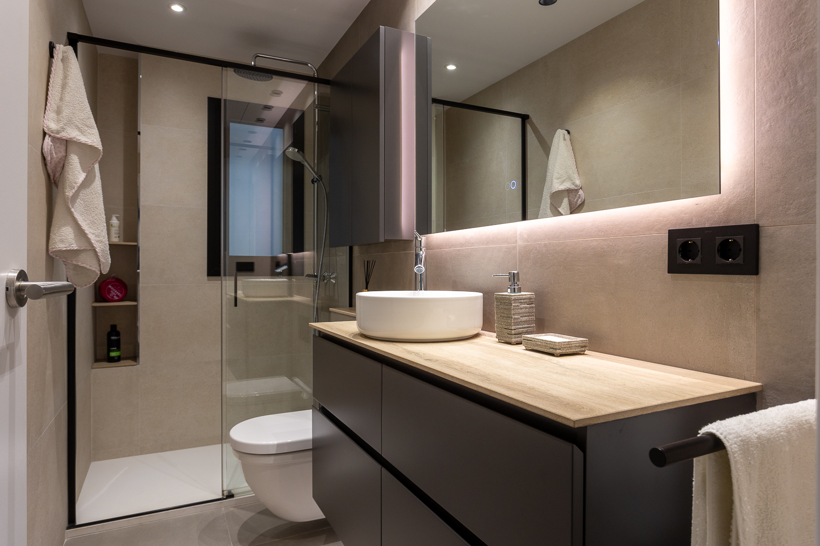 Baño negro con toques beige​